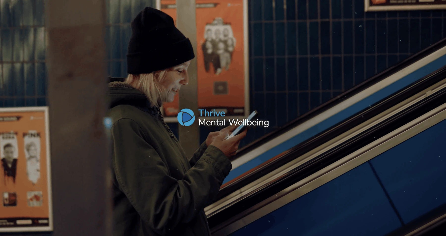 Thrive Mental Wellbeing service explainer showing a woman using her phone on an escalator